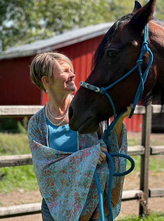 Rider and horse face to face in a rope halter, both at ease