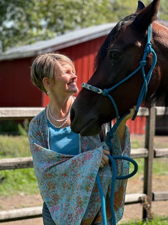 Tammy face to face with her horse in a rope halter, both at ease